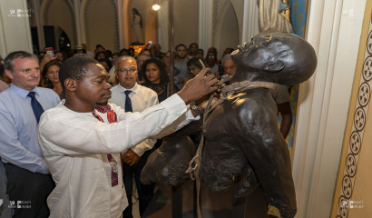 Le représentant du Bénin retire symboliquement les chaînes d'un esclave dans la chapelle pointue.